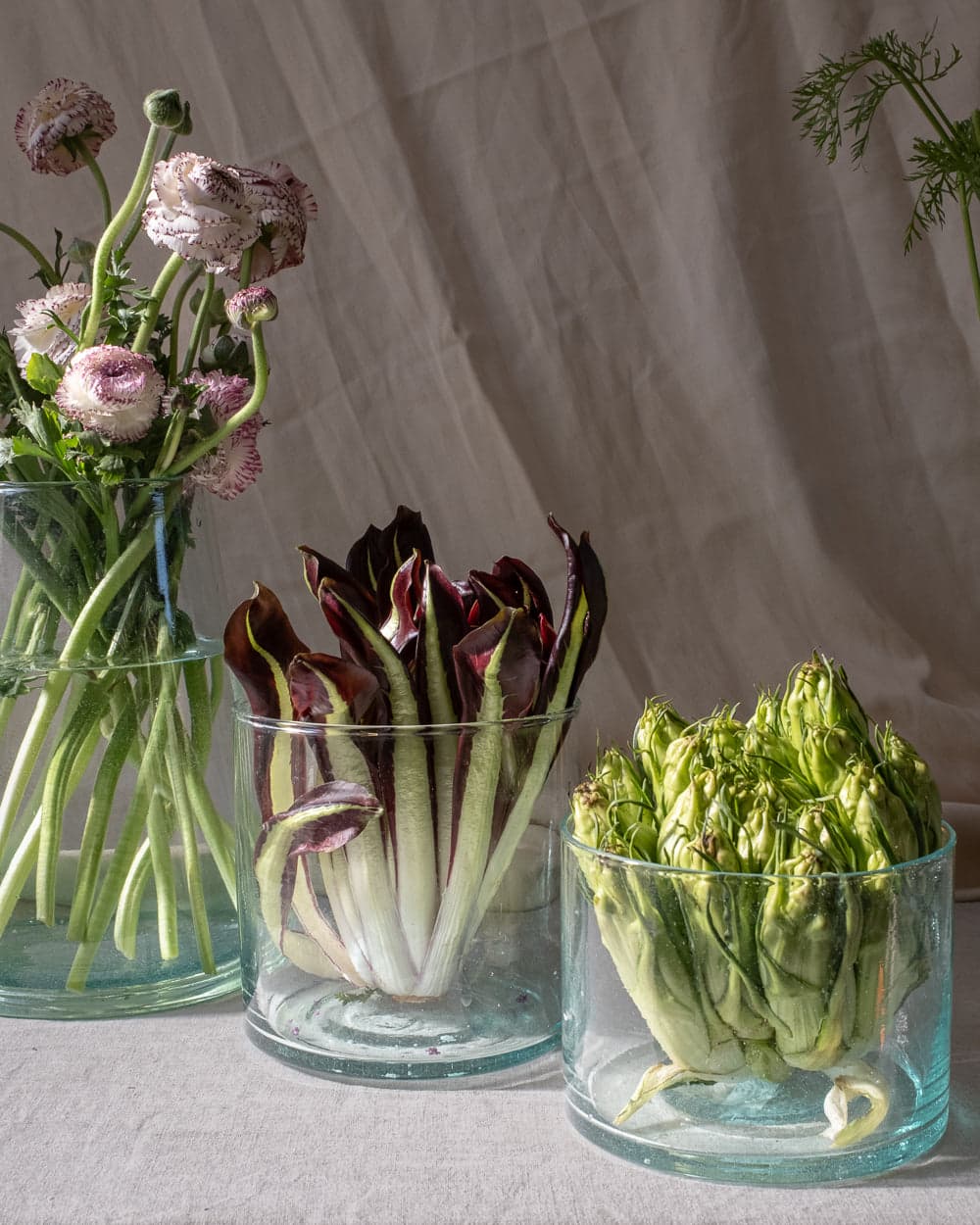Recycled-glass beldi hurricanes in three sizes, styled with flowers and produce